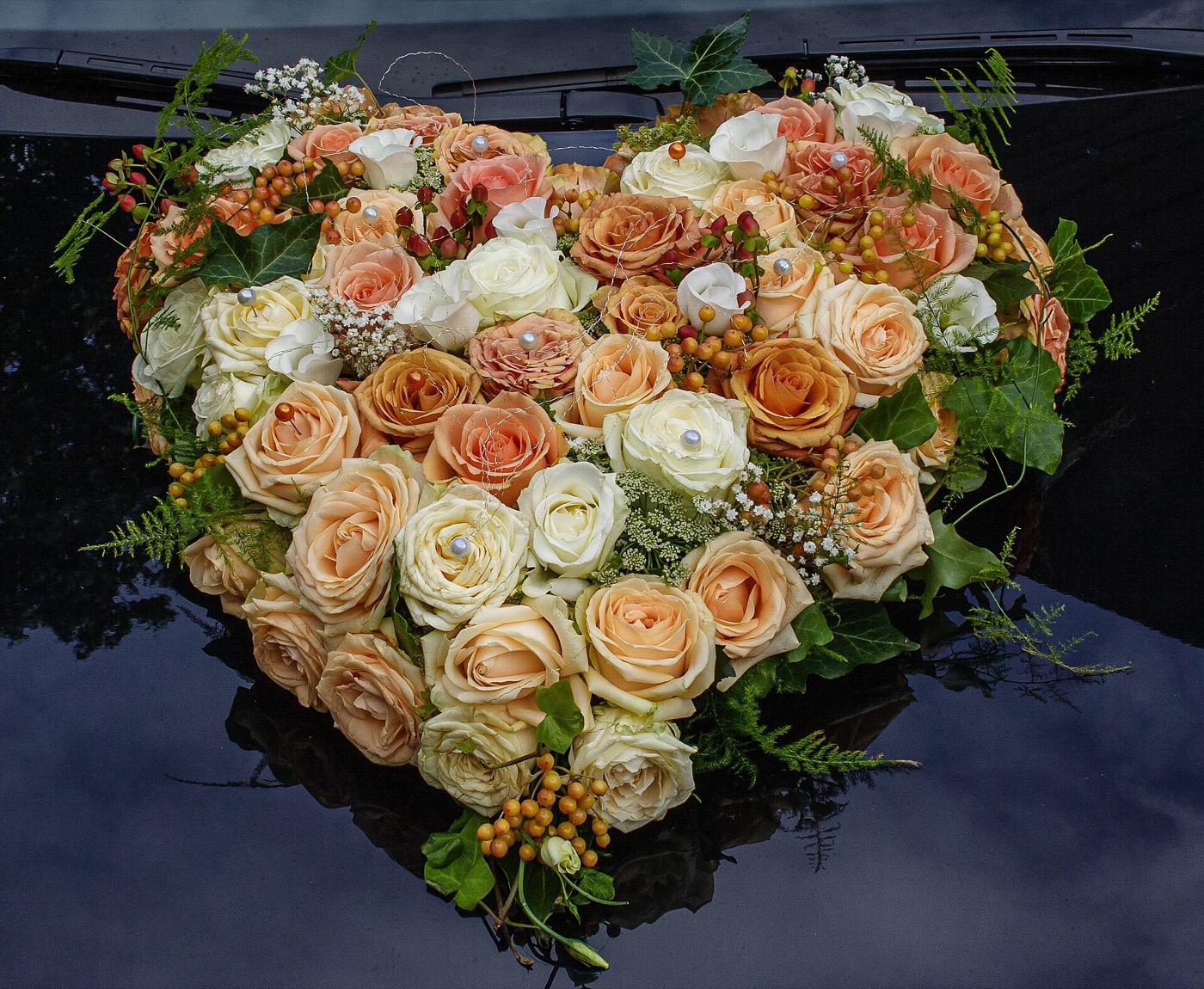 A large heart-shaped arrangement of peach and cream roses